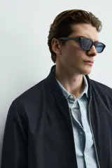 Sobrecamisa de corte regular fit en tejido técnico negro resistente al agua, con cuello estilo bomber en rib elástico, cierre frontal de cremallera y bolsillos plastrón con solapa en la cadera.