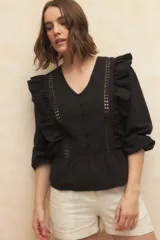 Blusa negra con textura, escote en V, mangas 3/4 abullonadas y detalles de encaje y volados en el frente.
