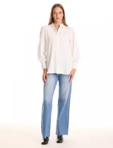 Camisa blanca de la marca Liv Los Ángeles, con cuello con solapa y cierre frontal de botones. Presenta mangas largas con detalles calados y puños anchos con botones.