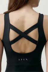Mono deportivo largo color negro, con diseño sin mangas, cuello redondo y piernas acampanadas con costuras frontales en relieve.