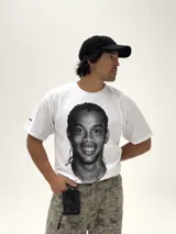 Remera blanca de corte boxy y diseño oversize, con estampa fotográfica frontal en blanco y negro del futbolista Ronaldinho.