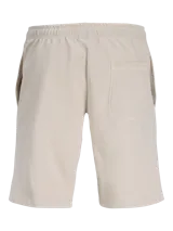 Short jogger de tejido de sudadera loopback color beige, con fit relajado, cintura elástica con cordón ajustable y el logo de Jack & Jones estampado verticalmente en la pierna.