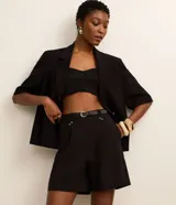 Short sastre de cintura alta de la marca Cortelle, color negro, con trabillas, pliegues delanteros y cinturón fino de poliuretano incluido.