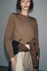 Jersey básico de cuello redondo y manga larga, confeccionado en hilatura de lana 100% con acabado de punto liso.