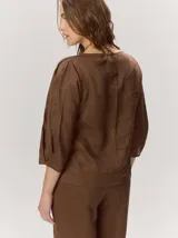 Blusa roja de manga larga con volumen sutil en las mangas y diseño holgado, confeccionada en algodón.