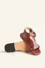 Sandalias negras de cuero con tiras finas, pulsera al tobillo con hebilla metálica y apliques de tachas plateadas.