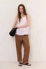 Pantalon de lino color verde militar, de corte recto y holgado, con cintura elastizada y cordón ajustable.