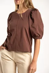 Remera de algodón negro con mangas cortas abullonadas, cuello redondo y costura central frontal.