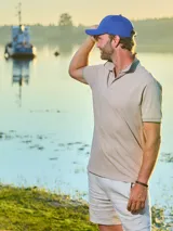 Remera tipo polo negra de algodón, con cuello y borde de mangas con línea blanca.