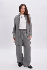 Pantalón jean de corte ancho y relajado, en color gris con efecto acid wash. Cuenta con cintura elastizada y cordón ajustable.