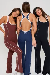 Mono deportivo largo de una pieza, color azul marino con detalles de líneas blancas verticales que recorren el torso y las piernas. Presenta escote redondo y espalda estilo nadador.