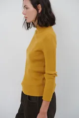 Polera de tejido morley color azul, con cuello alto y mangas largas, de corte ajustado al cuerpo.