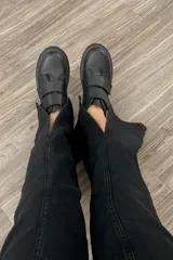 Jean negro de corte wide leg con tajo frontal y tiro medio alto.