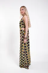 Vestido largo de tul con estampado de cuadrados de terciopelo multicolor, cuello halter atado a la nuca y aberturas laterales en la cintura.