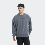 Buzo de cuello redondo Reef, color gris con efecto lavado, de corte holgado y mangas largas con puños acanalados. Presenta un pequeño logo bordado en el pecho.