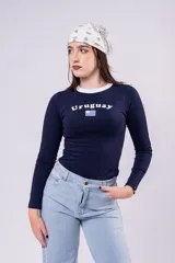 Remera de manga larga color azul marino con cuello redondo en contraste blanco. Presenta la palabra 'Uruguay' estampada en el pecho junto con la bandera nacional. Posee un corte ajustado al cuerpo.
