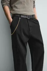Pantalón cargo de corte relajado confeccionado en tejido de algodón con elasticidad. Presenta bolsillos laterales tipo cargo con solapa en las perneras, bolsillos frontales y bolsillos traseros de doble vivo. Cierre frontal con cremallera y botón.