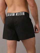 Pack de dos bóxer Calvin Klein de algodón elástico, uno negro y otro azul petróleo, con cinturilla elástica con logo de la marca.