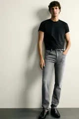 Jeans slim fit de color negro para hombre, con tiro medio, diseño de cinco bolsillos y cierre frontal con cremallera y botón.