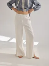 Pantalon de corte recto y tiro medio, confeccionado en lino, con cintura elastizada y tajos laterales en el ruedo.