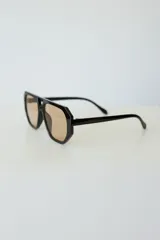 Lentes de sol con armazón de policarbonato negro y cristales tonalidad ámbar, con diseño de puente doble estilo aviador.