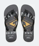 Chinelo de goma negro con tiras negras. La plantilla presenta un estampado en amarillo y blanco con motivos de California, incluyendo texto como "CALIFORNIA", "STATE OUTDOOR WILD", "GOLDEN NATURE" y un gráfico central con un oso.