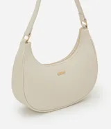 Cartera tipo baguette color beige, confeccionada en PU con acabado liso. Cuenta con cierre de cremallera y metales en tono dorado claro. El asa es ajustable y tiene un espacio interno ideal para el uso diario.