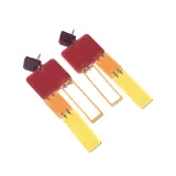 Par de aros colgantes con forma geométrica rectangular, hechos de acrílico en colores rojo, naranja y amarillo.