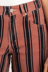 Jean wide leg de tiro alto con diseño de rayas verticales oscuras sobre base rosada, con bolsillos laterales y traseros y presillas para cinto.