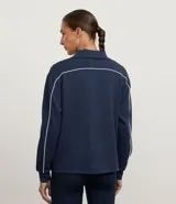 Campera deportiva azul marino de mujer, con cuello alto estructurado y cierre frontal. Presenta frisos o ribetes blancos contrastantes en la parte delantera y trasera.