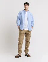 Pantalón de gabardina verde militar, corte cargo con bolsillos laterales con fuelle y tobillos ajustados con elástico.