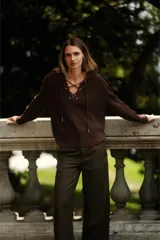 Sweater de punto color marrón chocolate, con capucha y escote acordonado con ojales metálicos. De corte holgado y manga larga.