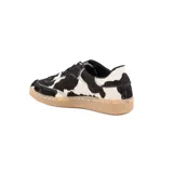 Championes de diseño artesanal con exterior de pelo natural con estampado de manchas tipo vaca en blanco y negro. Presenta cordones negros, interior forrado y suela de goma color caramelo.