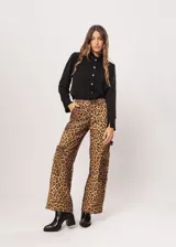 Camisa negra de cuello redondo con frunces y mangas largas con puños abiertos.