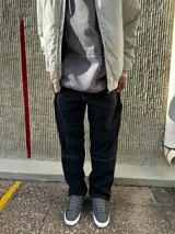 Pantalón de jean negro de corte recto, con bolsillos laterales y traseros, y presilla lateral para herramientas.