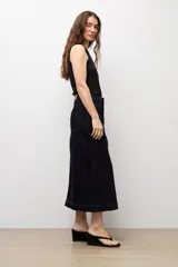 Falda midi de denim en color azul oscuro, con cierre frontal de botones metálicos y costuras a la vista.