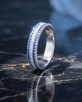 Anillo de plata 925 con diseño sin fin, compuesto por tres hileras de circonias: una central en color azul zafiro y dos laterales en color cristal.