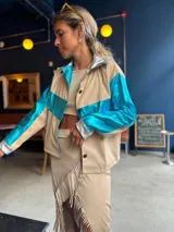 Camisa color beige con detalles en azul metalizado en mangas y pecho, y plateado en cuello y puños.