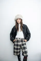 Bermuda de corte sastrero con diseño de cuadros escoceses en tonos beige y negro, de tiro alto y largo por debajo de la rodilla.