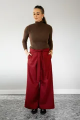 Pantalón de pierna recta con estampado de cuadros en tonos rojo y negro. Presenta cintura alta con lazo ajustable, elástico en la parte posterior de la pretina y cierre lateral.