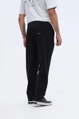Pantalón de jogging negro de felpa sin frisa, confeccionado en 100% algodón, de corte relajado y diseño liso.