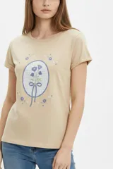 Remera de algodón color beige, de manga corta con vuelta, cuello redondo y estampa frontal de flores con lazo en tonos azules y celestes.