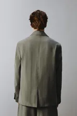 Blazer de corte relaxed fit confeccionada en tejido con mezcla de modal, en color verde militar. Presenta cuello con solapas de muesca, cierre frontal con un botón, bolsillos de vivo en el pecho y bolsillos con solapa en la cadera. Forro interior a rayas y abertura en el centro de la espalda.
