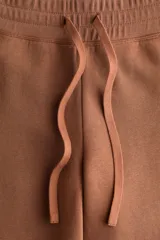Pantalón deportivo de felpa con diseño acampanado, cintura elástica con cordón ajustable e interior cepillado suave.