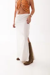 Top tipo halter de cuero color camel, con diseño de piezas orgánicas, perforaciones metálicas y detalles de tientos cruzados. Presenta un escote abierto y estructura firme.