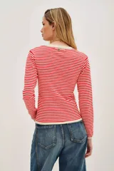 Remera de punto de manga larga con diseño de rayas horizontales en color rojo y beige, cuello redondo y ajuste cómodo.