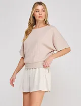 Blusa Allie Rose de punto liviano color beige, con trama texturada en relieve de efecto gofrado, silueta relajada, escote redondo amplio, mangas cortas holgadas de corte mariposa y ruedo con pretina ancha.
