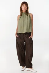 Blusa de lino italiano color marrón oscuro, con corte en línea A, hombros descubiertos, escote halter con frunces y volado en el cuello.