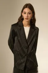 Blazer negro de poliéster con diseño de rombos formados por strass, cuello solapa, cierre frontal con botones y bolsillos laterales.