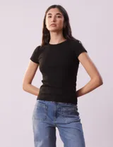 Remera negra de tejido acanalado, marca Cyrus, con escote a la base y manga corta.